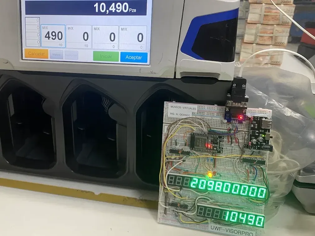 Contadora de billetes de varios bolsillos con su pantalla de conteo y, al lado, el visor externo de Mundos Virtuales armado en una placa de pruebas con displays verdes