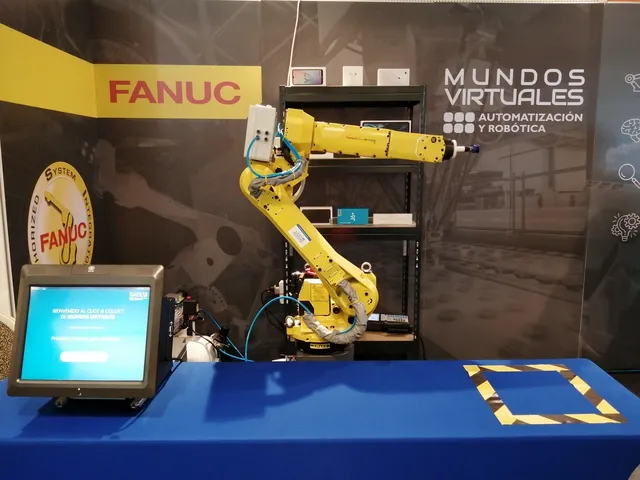 Equipo de Mundos Virtuales en exposición técnica junto a equipamiento FANUC
