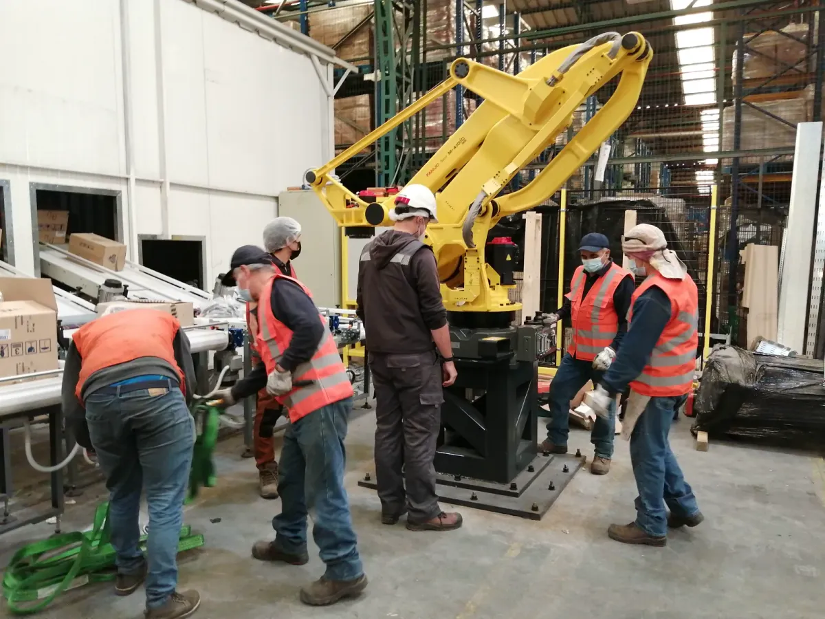 Técnicos de Mundos Virtuales instalando un robot FANUC de paletizado en planta