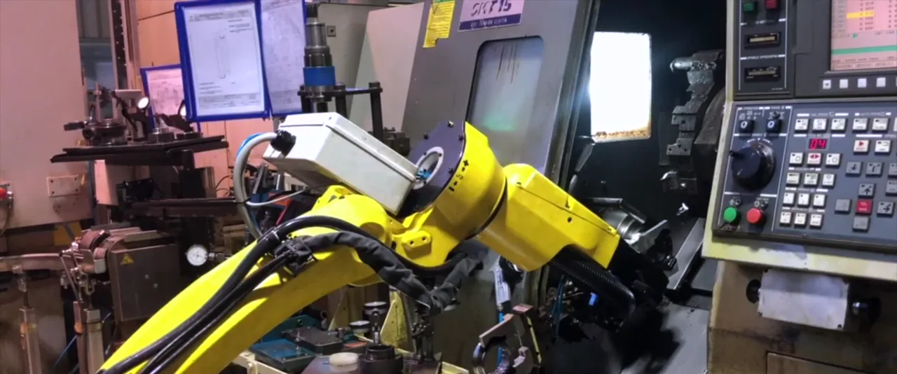 Robot FANUC cargando piezas en un torno CNC