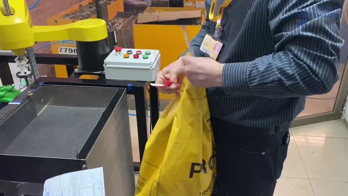 Operador manejando efectivo en sucursal junto al sistema robotizado de billetes