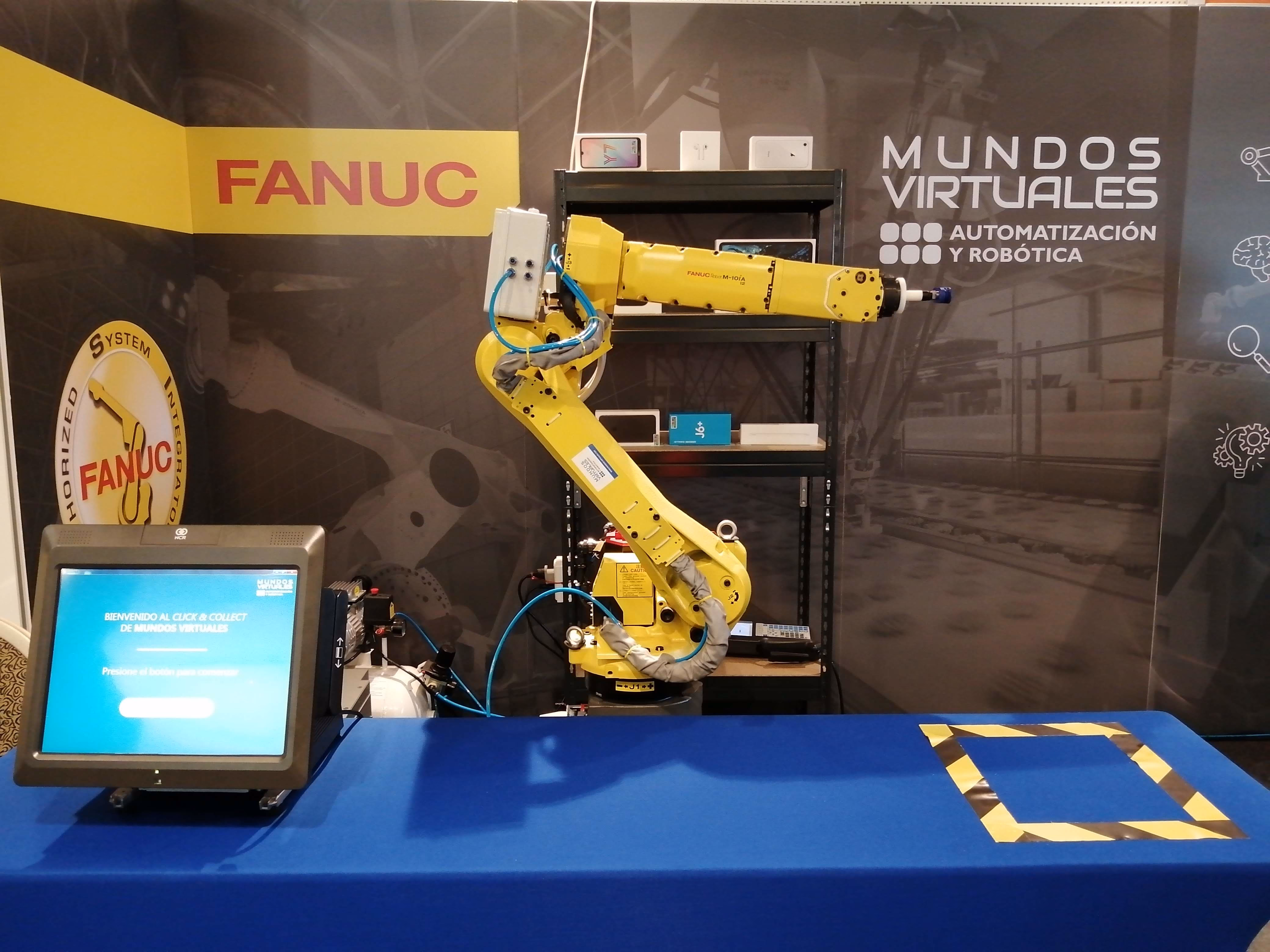Equipo de Mundos Virtuales en exposición técnica junto a equipamiento FANUC