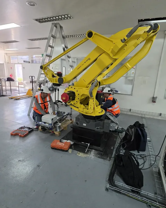 Equipo de Mundos Virtuales instalando un robot FANUC de paletizado en planta industrial
